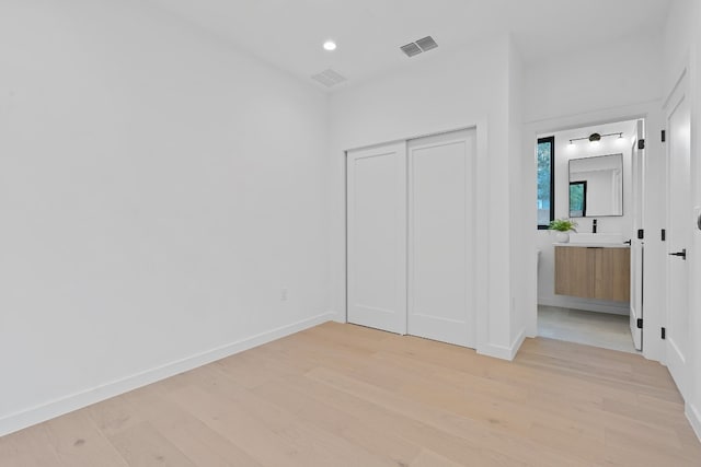 unfurnished bedroom featuring a closet and light wood-type flooring