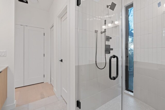 bathroom featuring vanity, tile patterned flooring, and walk in shower