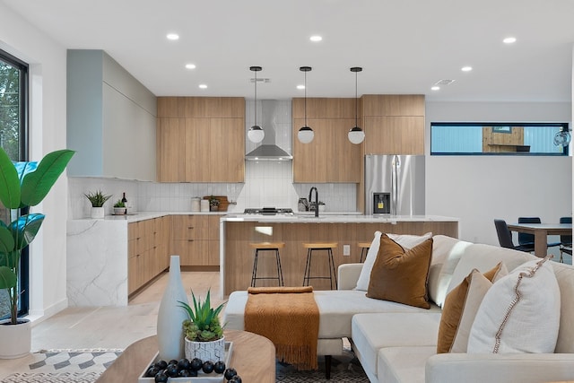 2704 Canterbury St Unit A, Austin, TX 78702 - interior space featuring wall chimney range hood, light countertops, modern cabinets, and stainless steel fridge