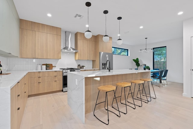2704 Canterbury St Unit A, Austin, TX 78702 - kitchen featuring wall chimney range hood, stainless steel appliances, modern cabinets, and visible vents