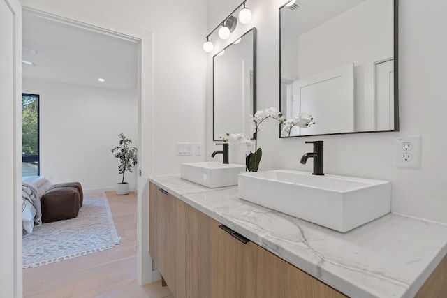 2704 Canterbury St Unit A, Austin, TX 78702 - bathroom featuring double vanity, wood finished floors, baseboards, and a sink