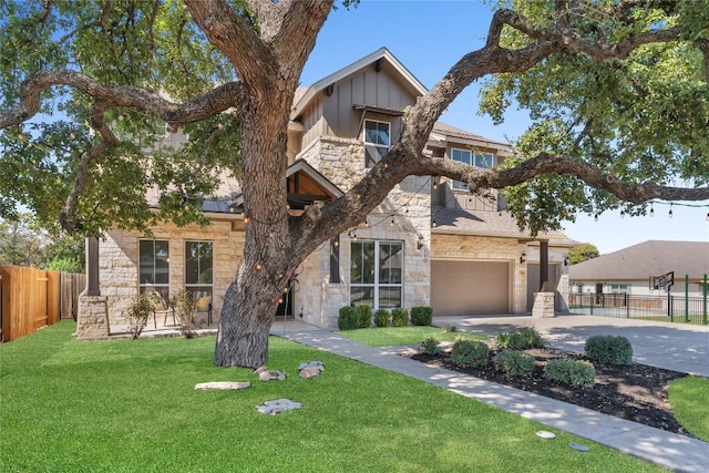 110 Magona Trl, Georgetown, TX 78628 - view of front of house featuring concrete driveway, a front yard, board and batten siding, and stone siding