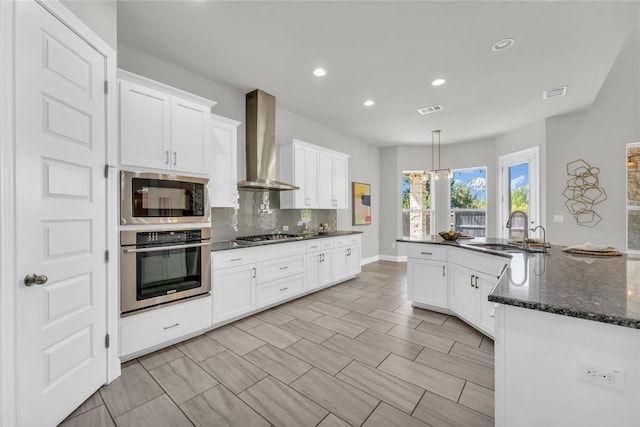 110 Magona Trl, Georgetown, TX 78628 - kitchen featuring wall chimney range hood, backsplash, visible vents, a sink, and stainless steel appliances