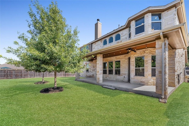 110 Magona Trl, Georgetown, TX 78628 - back of property with stone siding, a chimney, a patio, and ceiling fan