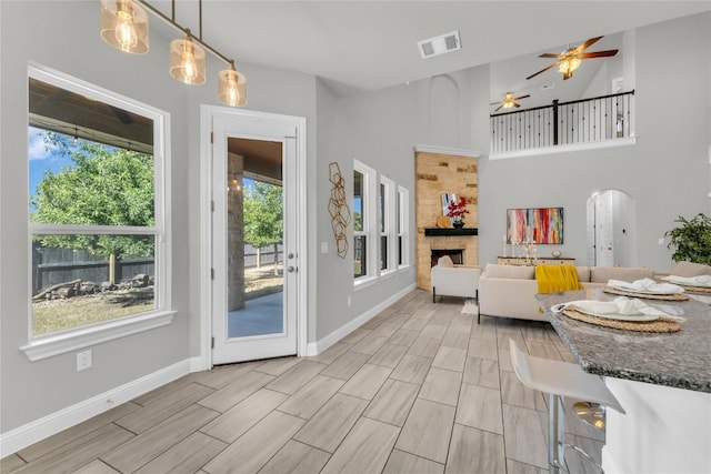 110 Magona Trl, Georgetown, TX 78628 - dining area with healthy amount of natural light, a fireplace, arched walkways, and a ceiling fan