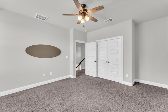 unfurnished bedroom featuring a closet, ceiling fan, and dark colored carpet