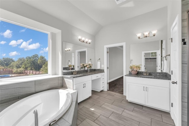 110 Magona Trl, Georgetown, TX 78628 - bathroom featuring a garden tub, two vanities, a chandelier, a sink, and vaulted ceiling