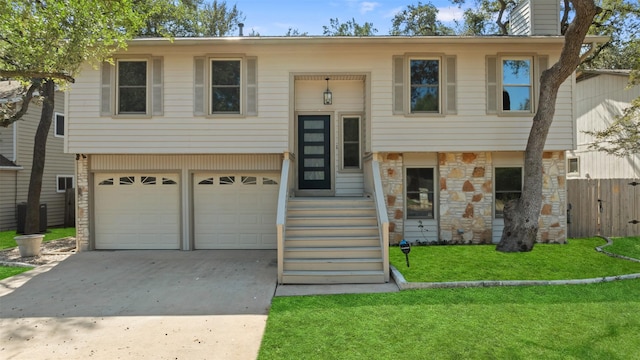 split foyer home with a front yard and a garage