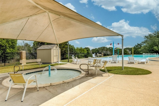 view of pool with a patio area and a storage unit