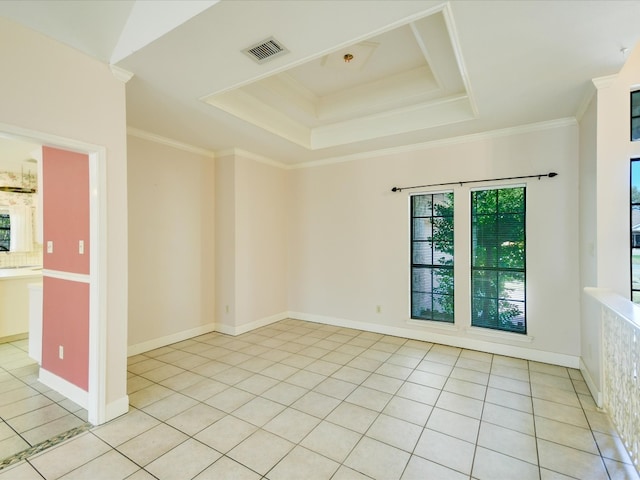 unfurnished room with crown molding, a tray ceiling, and light tile patterned floors