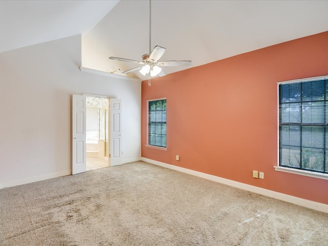 empty room featuring light carpet, high vaulted ceiling, and ceiling fan