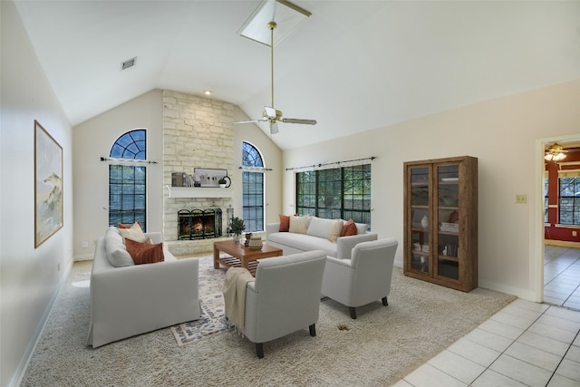 tiled living room featuring a fireplace, high vaulted ceiling, and ceiling fan