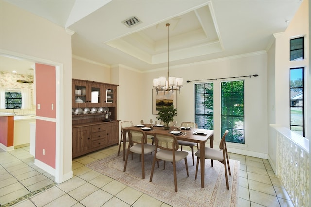 dining room with a raised ceiling, a notable chandelier, crown molding, and light tile patterned floors