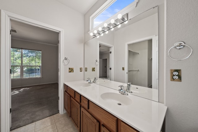 bathroom featuring tile patterned floors, vanity, a healthy amount of sunlight, and ornamental molding