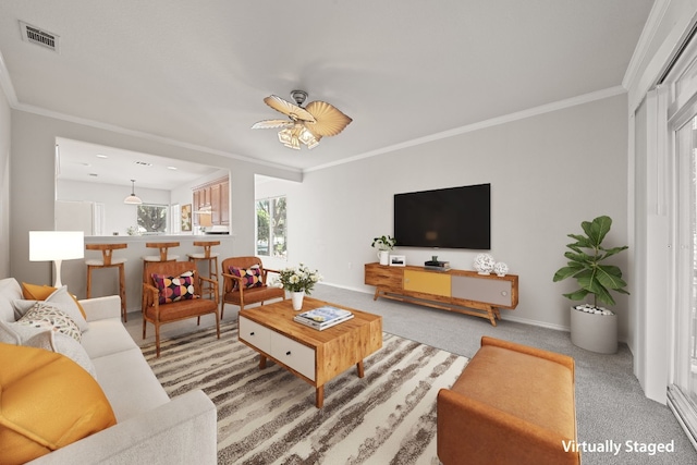 carpeted living room featuring ceiling fan and crown molding