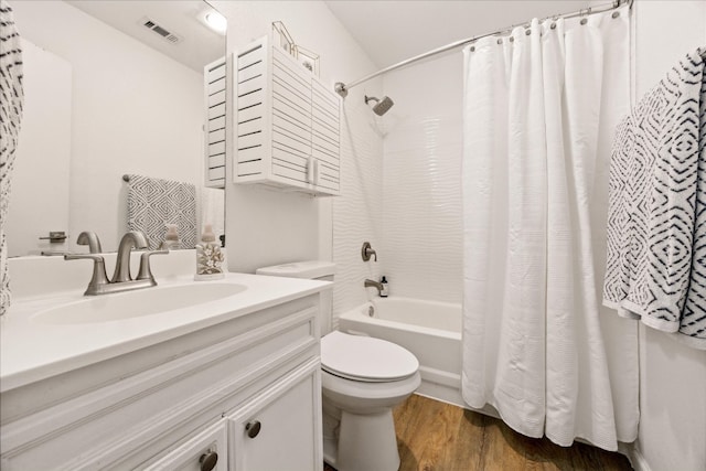 full bathroom featuring wood-type flooring, vanity, shower / tub combo with curtain, and toilet