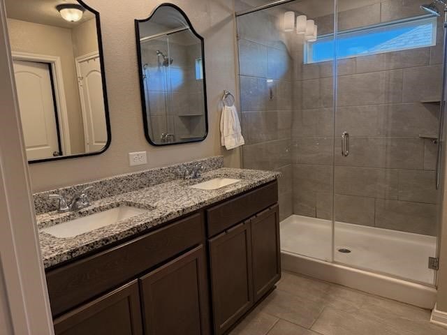 bathroom featuring vanity, tile patterned flooring, and walk in shower