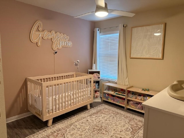 bedroom with ceiling fan, sink, hardwood / wood-style floors, and a crib