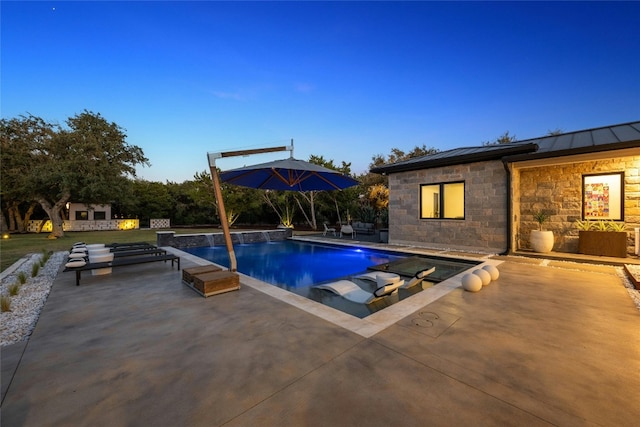 pool at dusk featuring a patio