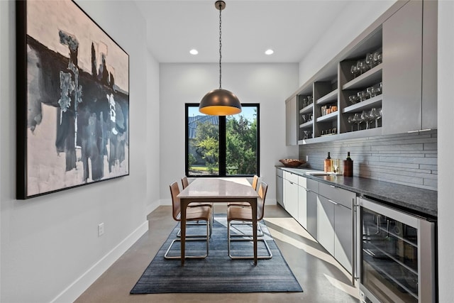 interior space featuring wine cooler, indoor bar, and concrete floors