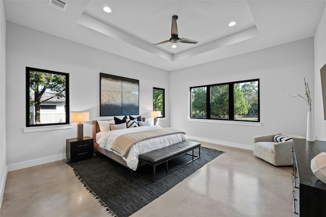 bedroom with ceiling fan and a tray ceiling