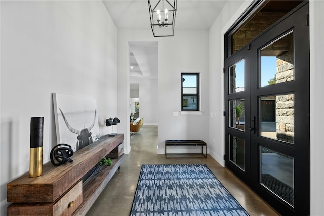 corridor featuring a towering ceiling and an inviting chandelier