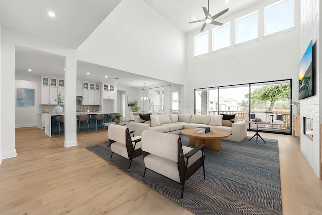2305 Shane Ranch Dr, Cedar Park, TX 78641 - living room with a ceiling fan, light wood finished floors, a high ceiling, a fireplace, and recessed lighting