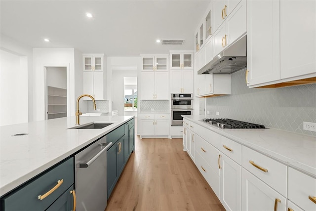 2305 Shane Ranch Dr, Cedar Park, TX 78641 - kitchen with appliances with stainless steel finishes, under cabinet range hood, backsplash, white cabinets, and recessed lighting