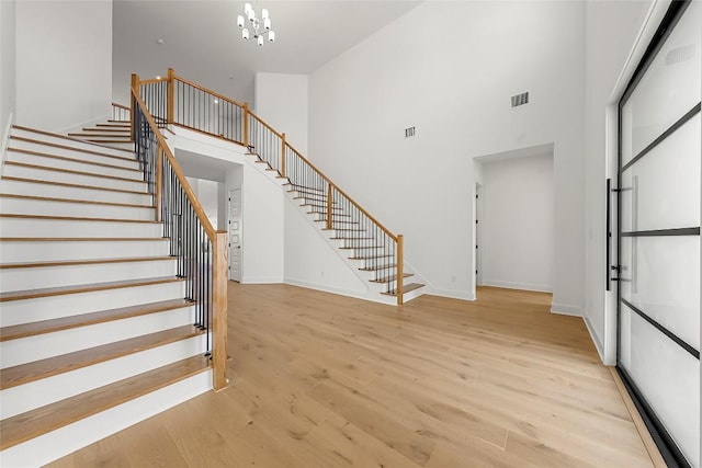2305 Shane Ranch Dr, Cedar Park, TX 78641 - staircase featuring a high ceiling, wood finished floors, and a chandelier