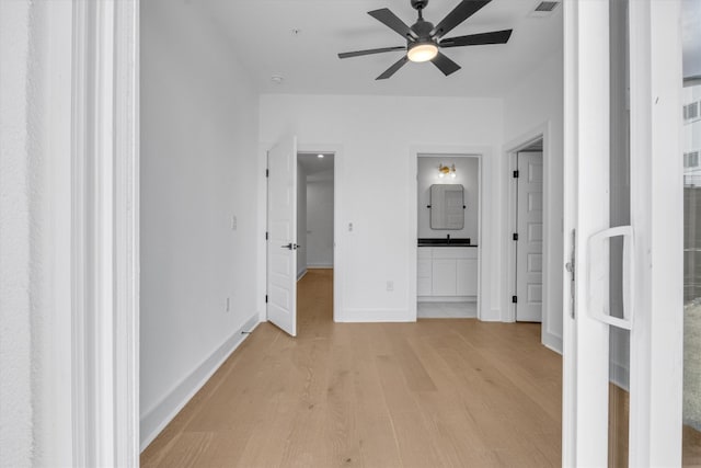 unfurnished bedroom with connected bathroom, light hardwood / wood-style flooring, and ceiling fan