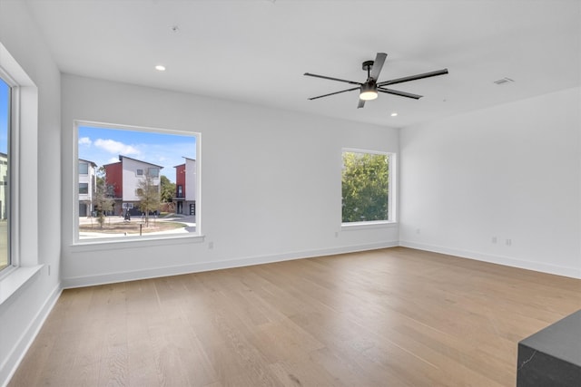 unfurnished room with light hardwood / wood-style flooring, plenty of natural light, and ceiling fan