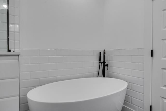 bathroom with tile walls and a bathing tub