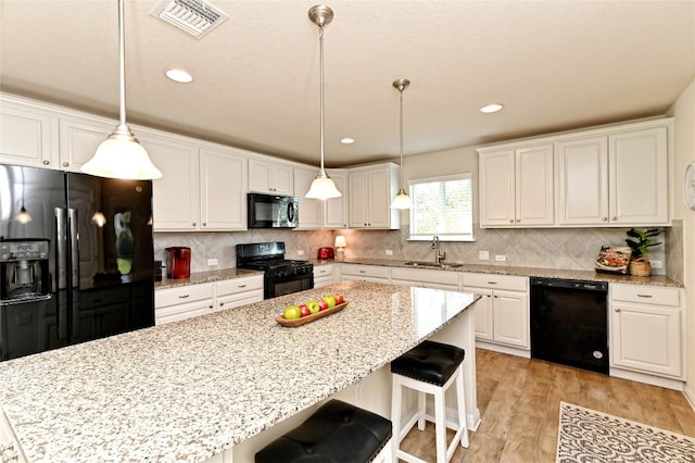 kitchen featuring black appliances, decorative backsplash, white cabinets, and sink