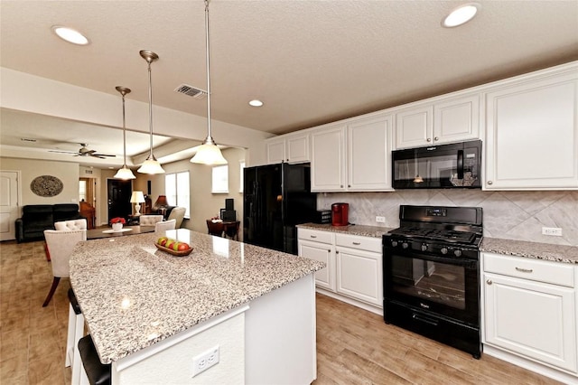 kitchen with backsplash, black appliances, white cabinets, hanging light fixtures, and ceiling fan