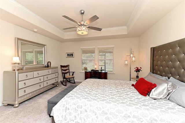 carpeted bedroom with multiple windows, a tray ceiling, and ceiling fan