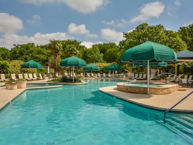 view of swimming pool featuring a hot tub and a patio area