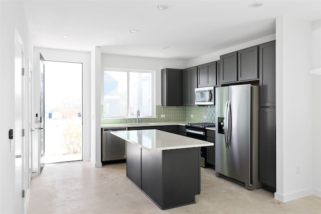 kitchen with sink, backsplash, appliances with stainless steel finishes, and a center island