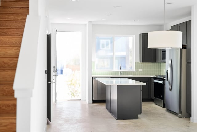 kitchen featuring a center island, sink, backsplash, and stainless steel appliances