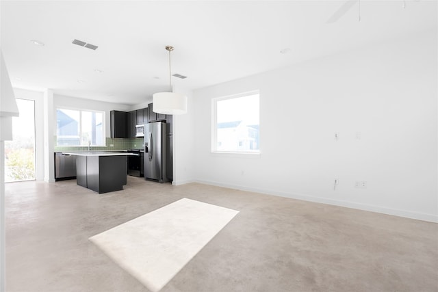 kitchen with a center island, hanging light fixtures, a wealth of natural light, and stainless steel appliances