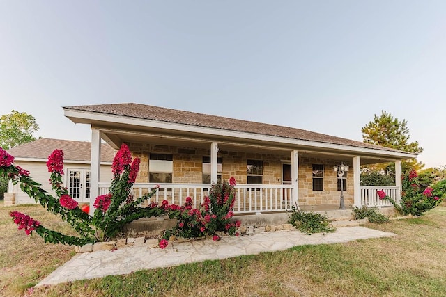 view of front of house featuring covered porch and a front yard