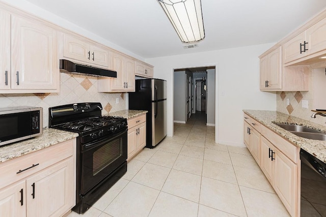 kitchen with sink, backsplash, black appliances, light stone countertops, and light tile patterned flooring