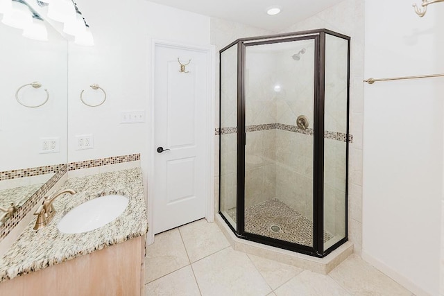 bathroom featuring tile patterned floors, vanity, and a shower with shower door