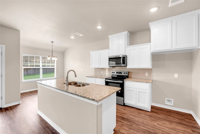 kitchen with appliances with stainless steel finishes, sink, an island with sink, pendant lighting, and white cabinets