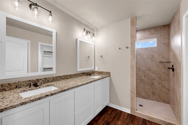 bathroom with vanity, tiled shower, and hardwood / wood-style floors