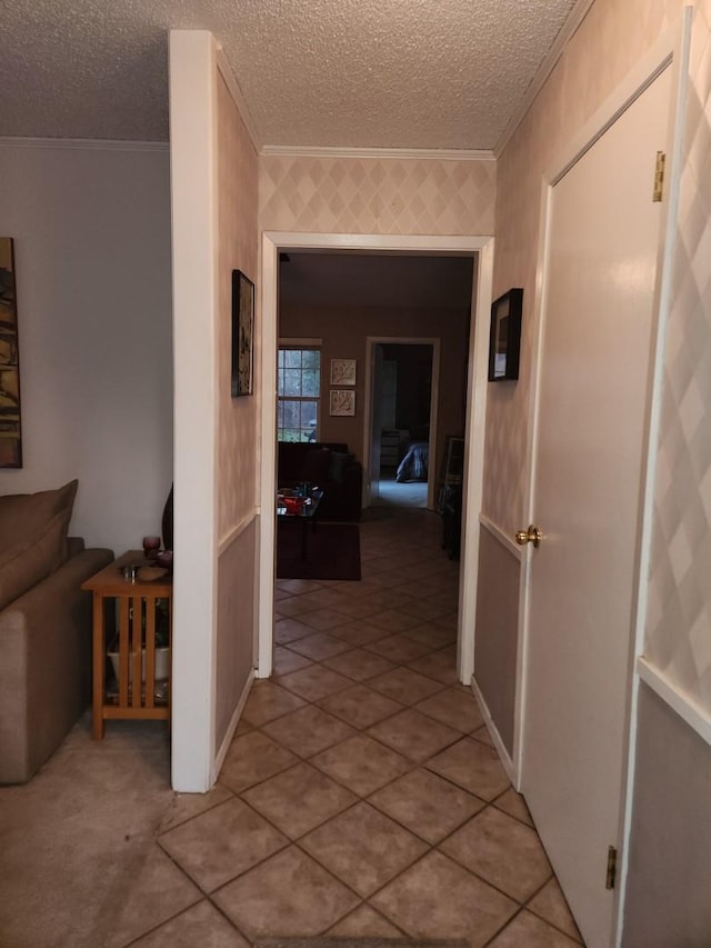 hallway with crown molding and a textured ceiling