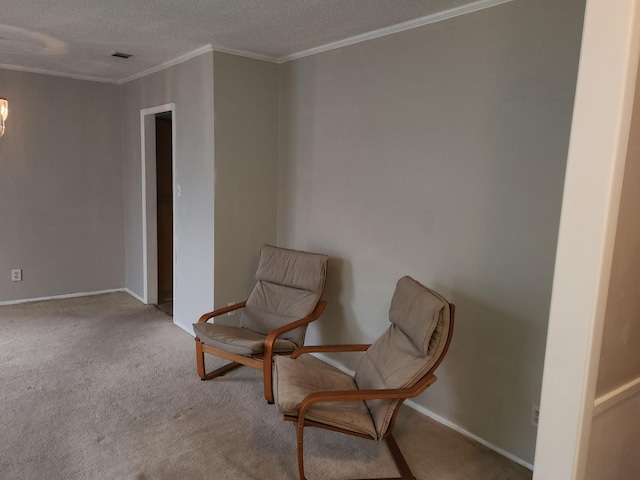 sitting room with crown molding, light colored carpet, and a textured ceiling