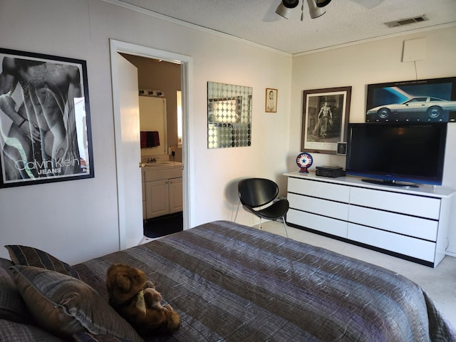 carpeted bedroom with sink, ceiling fan, connected bathroom, ornamental molding, and a textured ceiling