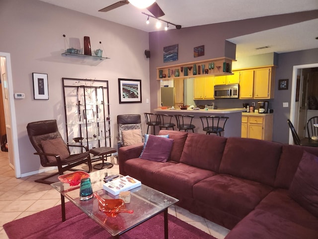 tiled living room with ceiling fan and rail lighting