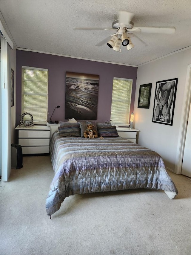 carpeted bedroom with ceiling fan and a textured ceiling