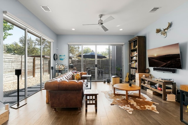 living room with a ceiling fan, wood finished floors, visible vents, and recessed lighting
